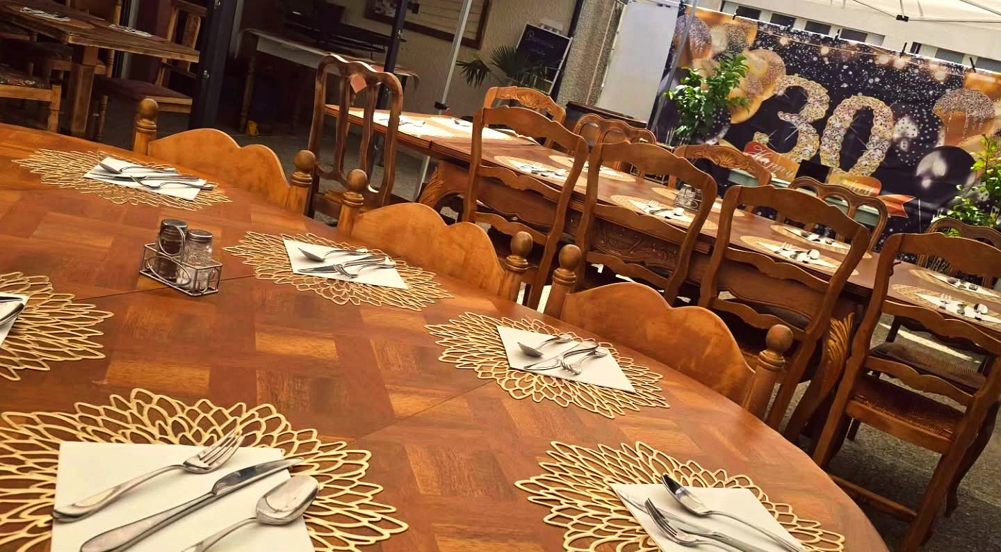 Grande tablée dressée pour un anniversaire, sets de table dorés et couverts